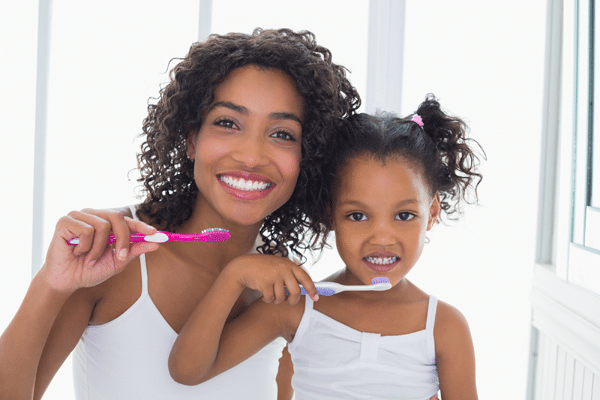 Mom and daughter smiling and brushing teeth American River Orthodontics Sacramento