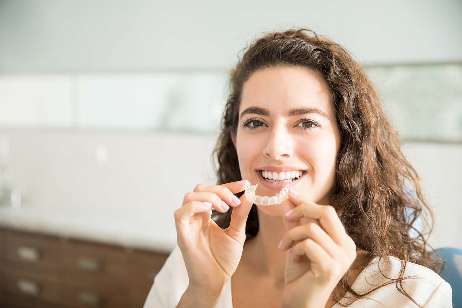 woman is pleased with her Invisalign treatment