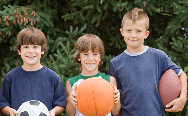young boys holding sports balls