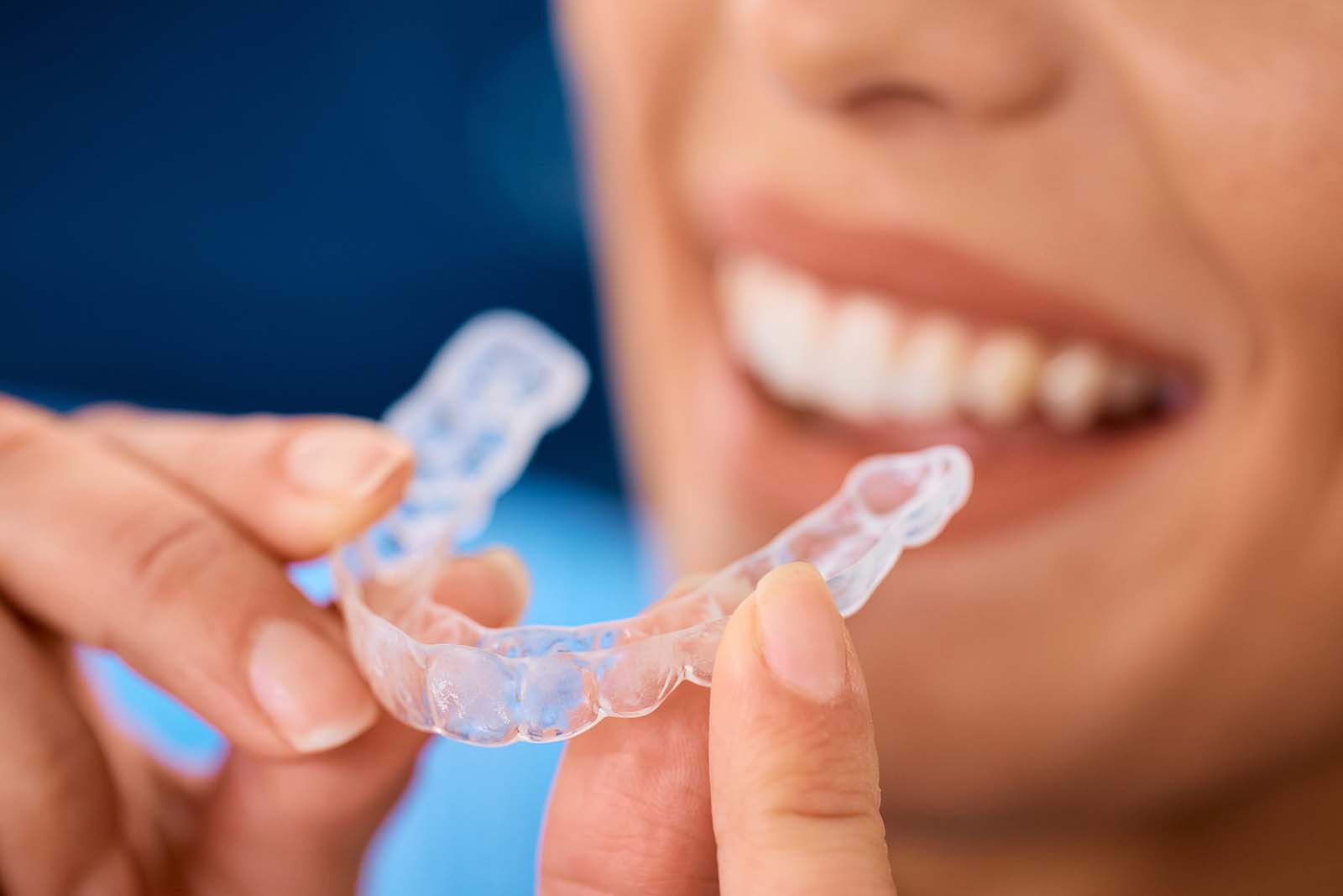 Invisalign is one of the top orthodontic treatments around the world woman inserting a clear aligner for orthodontic treatment
