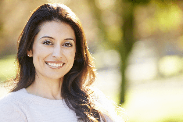 smiling woman outdoors wearing clear aligners in Roseville, CA