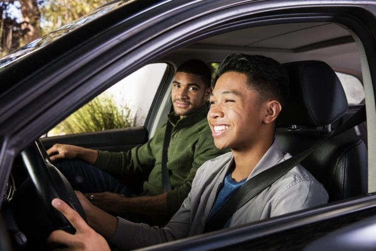 father teaching his teen son to drive