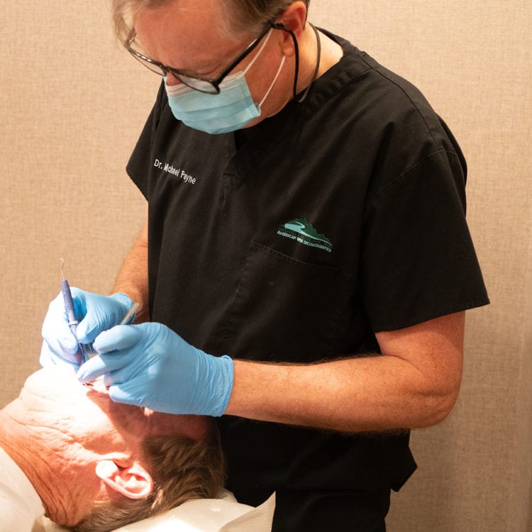 Dr. Michael H. Payne of American River Orthodontics examining a patient