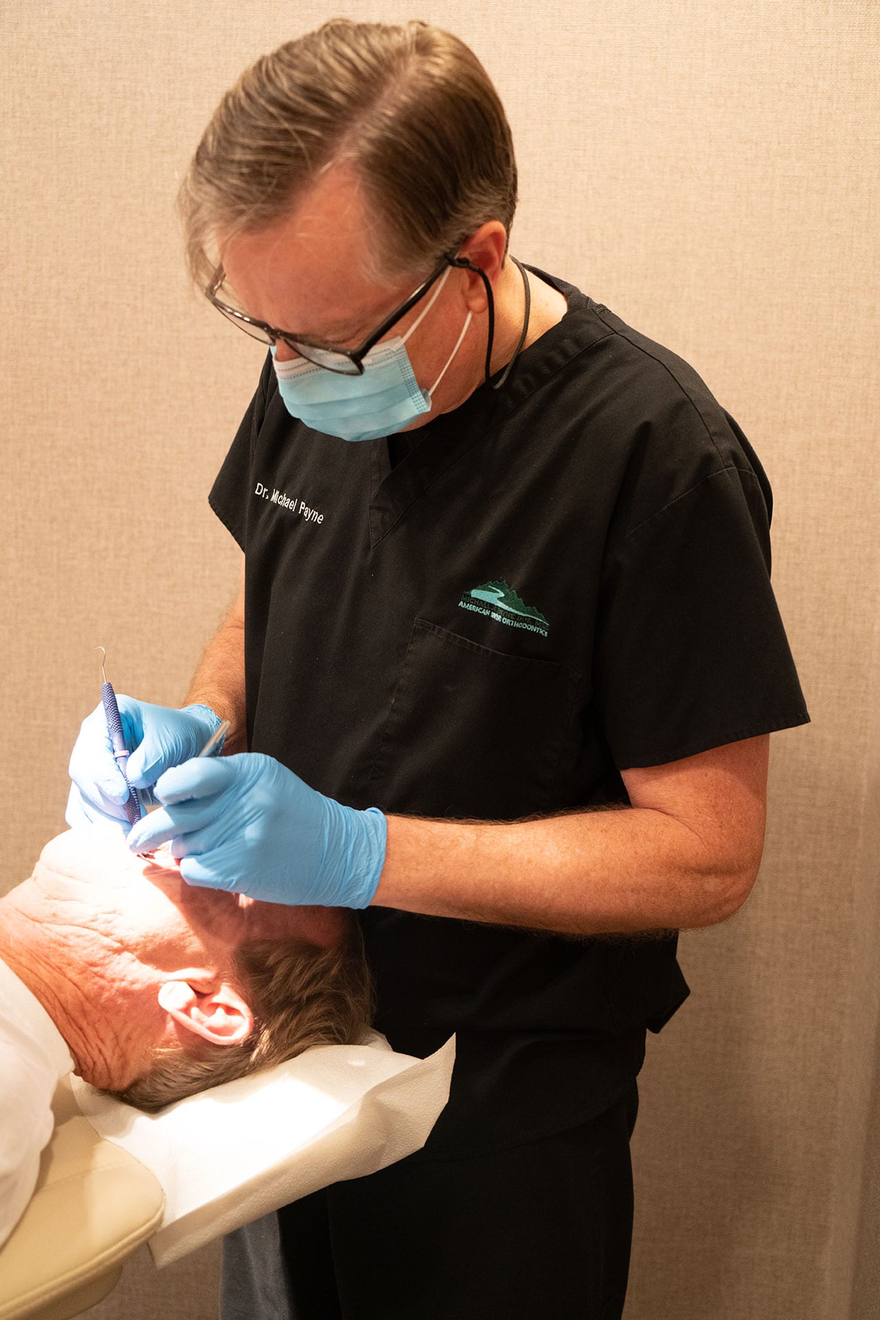 Dr. Michael H. Payne of American River Orthodontics examining an orthodontic patient at the Sacramento office