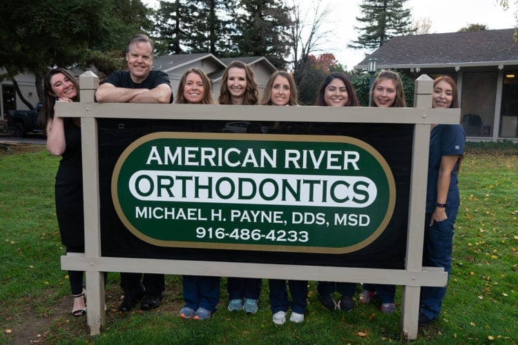 American River Orthodontics team outside next to sign