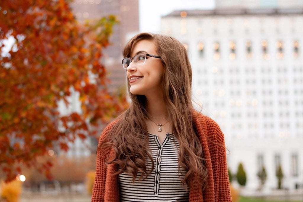 Carmichael woman wearing glasses and straightening her teeth with dental braces.