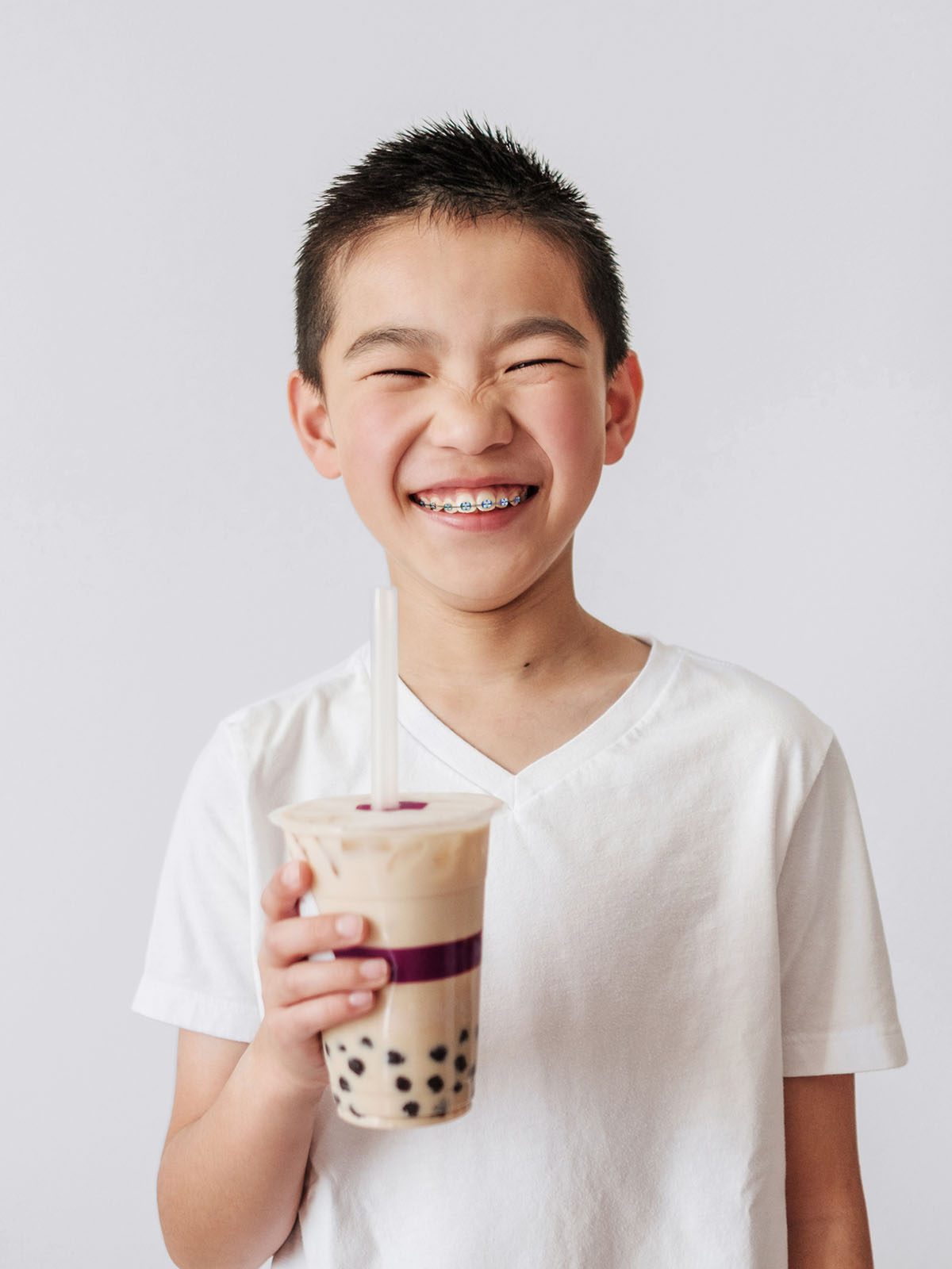 Young boy drinking boba tea and happy about his braces from his family orthodontist near Arden Arcade, Sacramento