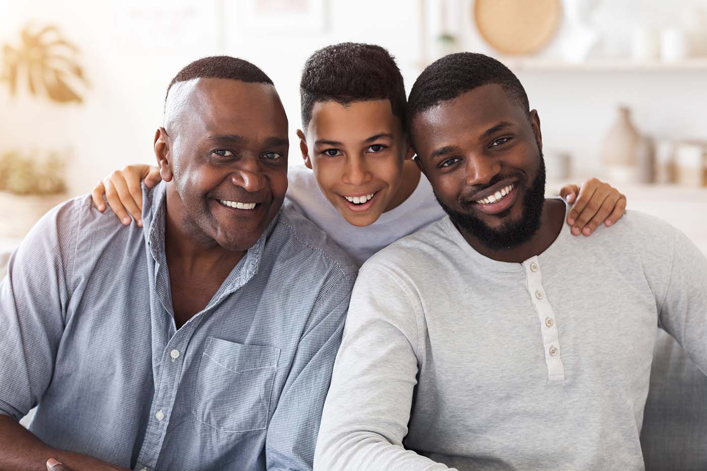 Three generations of smiling men from a family from Carmichael. 3 generations of a family all with stunning smiles after visiting the family orthodontist for Carmichael