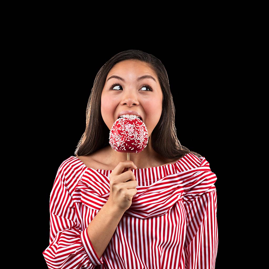 Teenage girl eating a candy apple that's too sticky for traditional metal braces