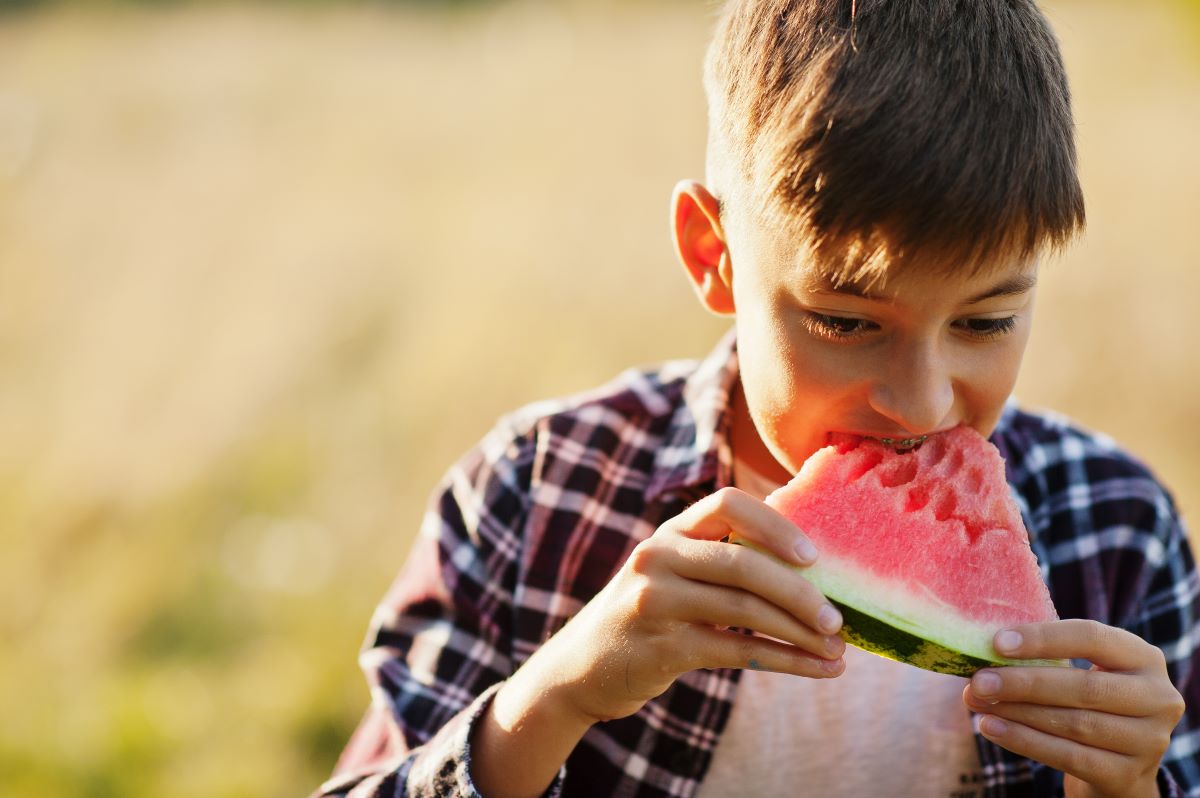teen-boy-wear-checkered-shirt-with-braces-eating-watermelon