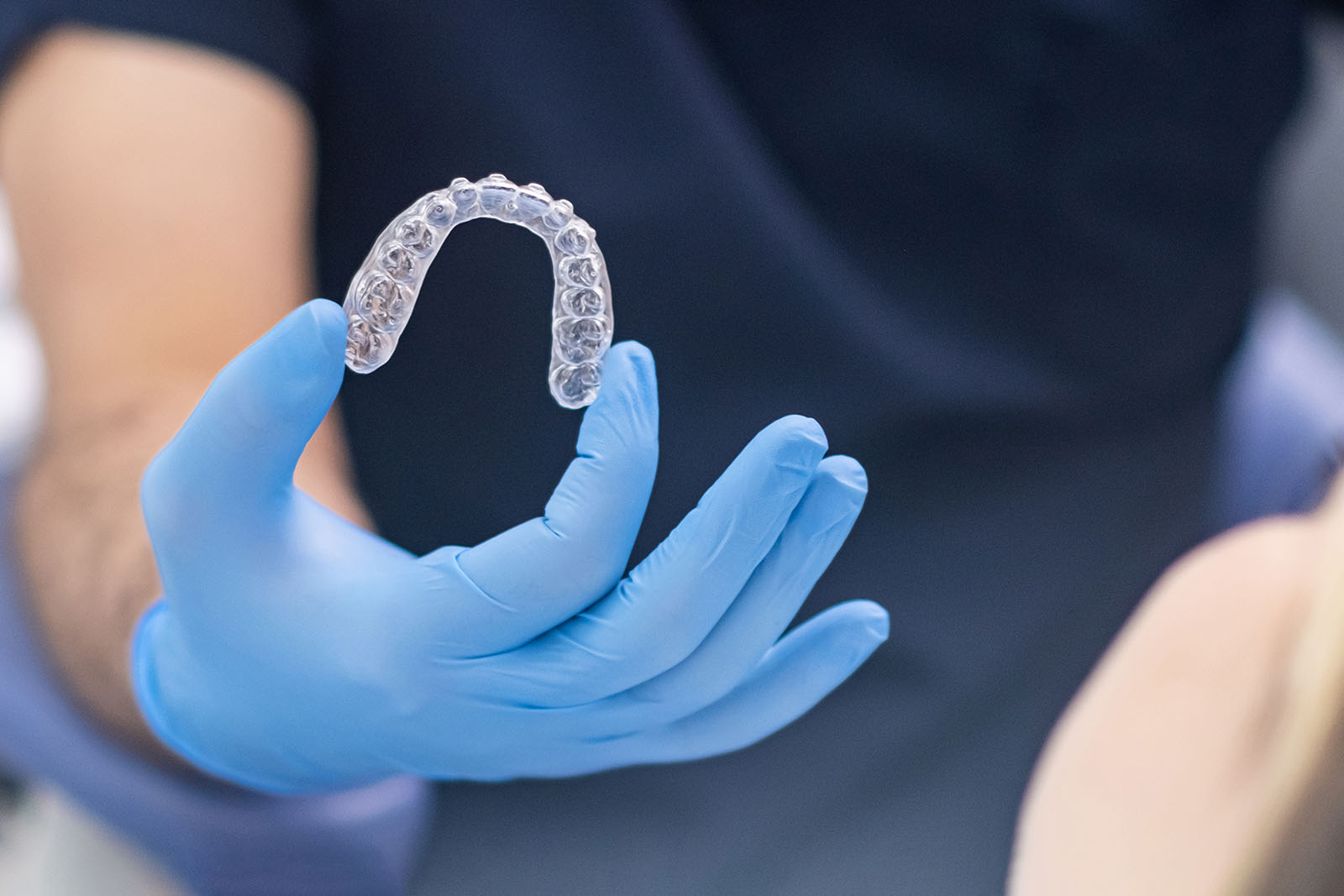 orthodontist holding a clear Invisalign aligner orthodontist holding a clear Invisalign aligner