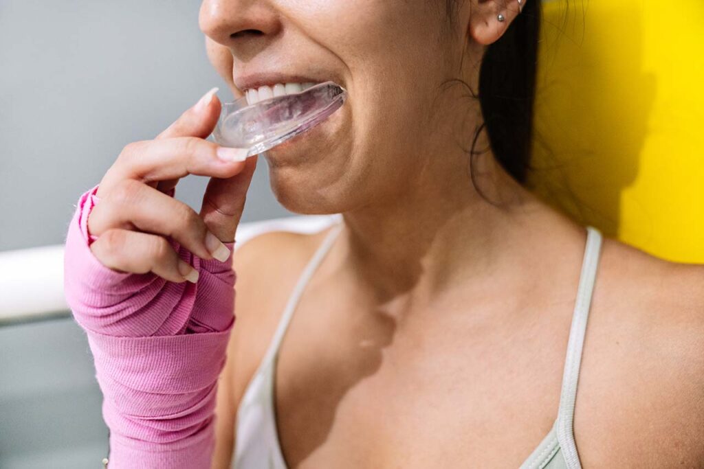 female athlete inserting a mouthguard