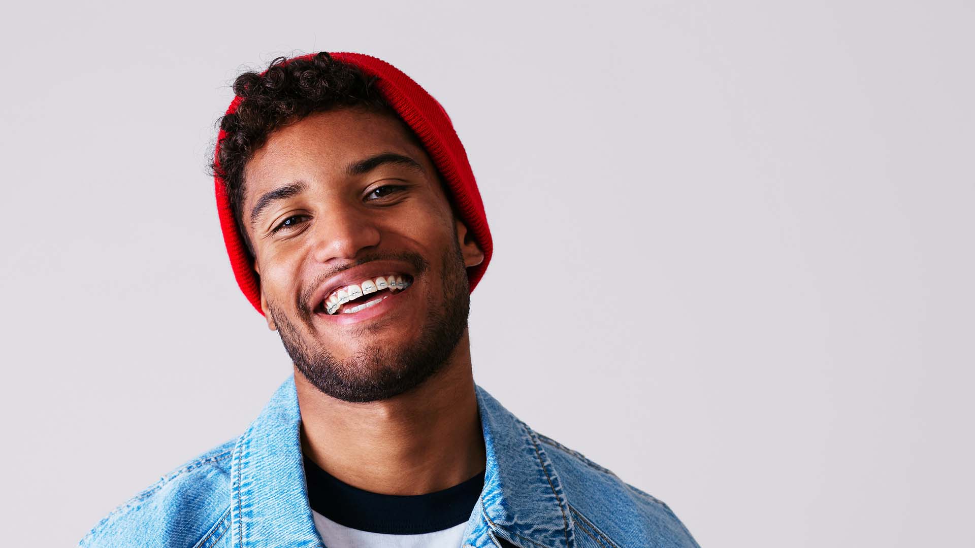 LightForce treatment begins with a digital scan of your mouth to create 3D-printed custom brackets to fit every tooth perfectly Young man wearing custom clear LightForce brackets