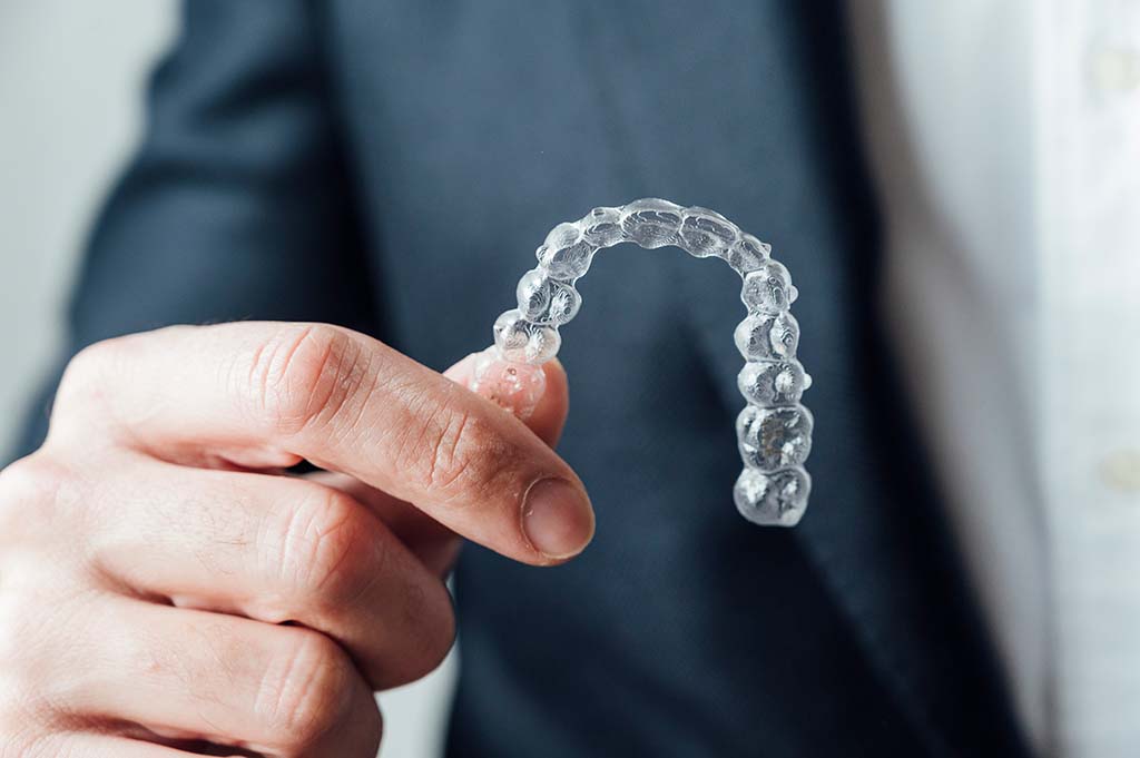 businessman holding a clear aligner to fix minor issues Clear aligners are commonly used for minor orthodontic treatment