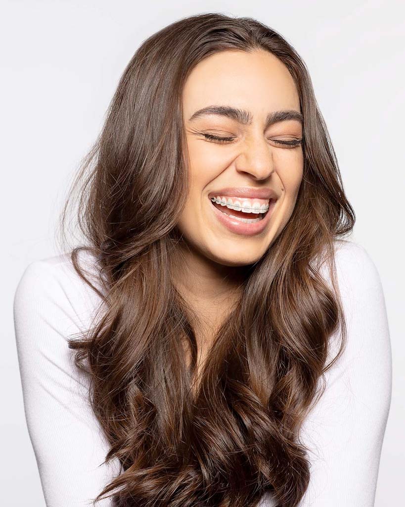 Portrait of an excited smiling woman in clear LightForce brackets