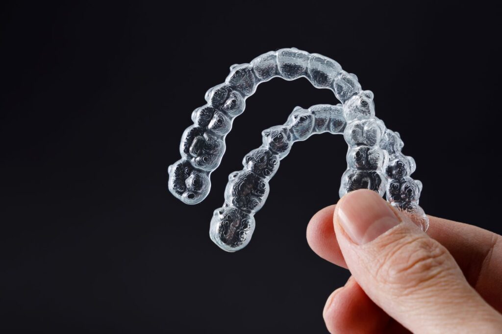 Person holding Invisalign aligners